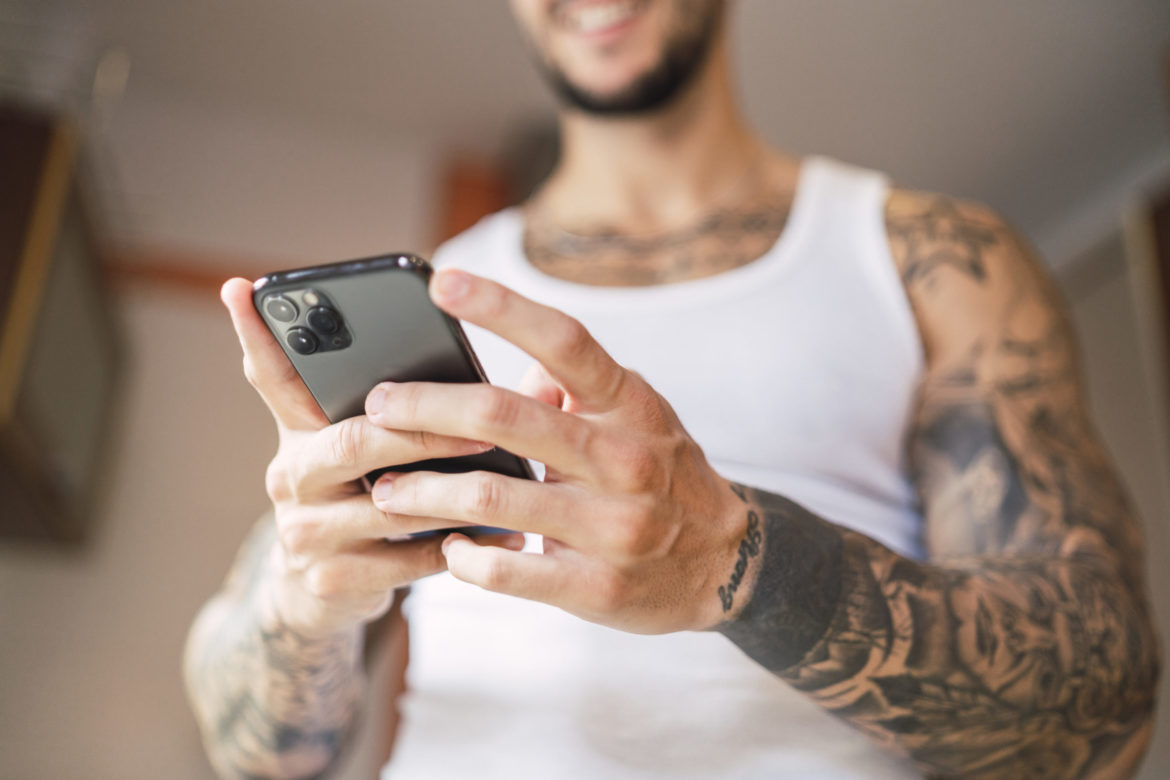 shallow-focus-shot-caucasian-fit-male-using-his-smartphone