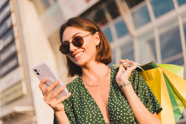 nő a plázában a telefonját nézi